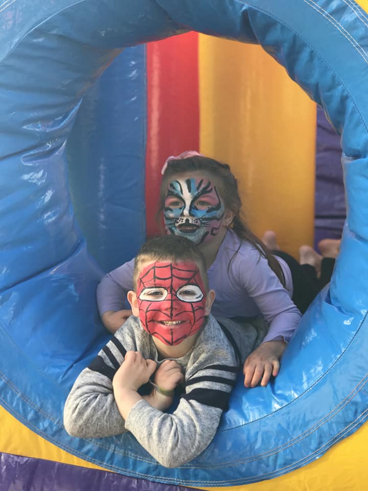 Kids with face paint inside a jumping castle